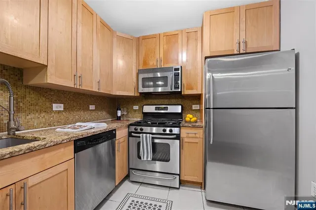 a kitchen with granite countertop a refrigerator stove and microwave