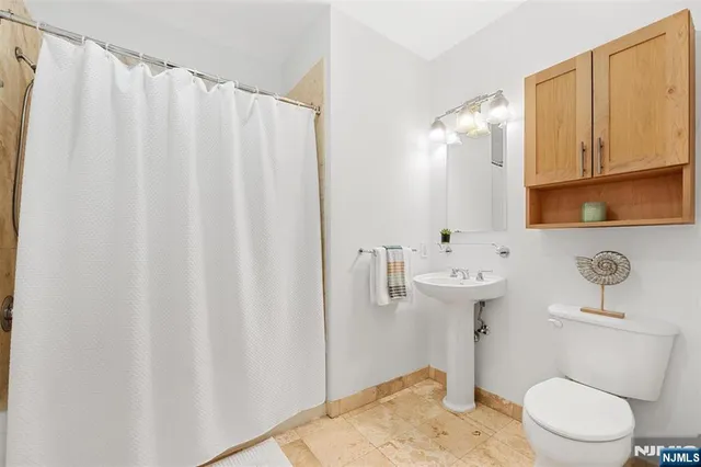 a bathroom with a sink a toilet and shower curtain