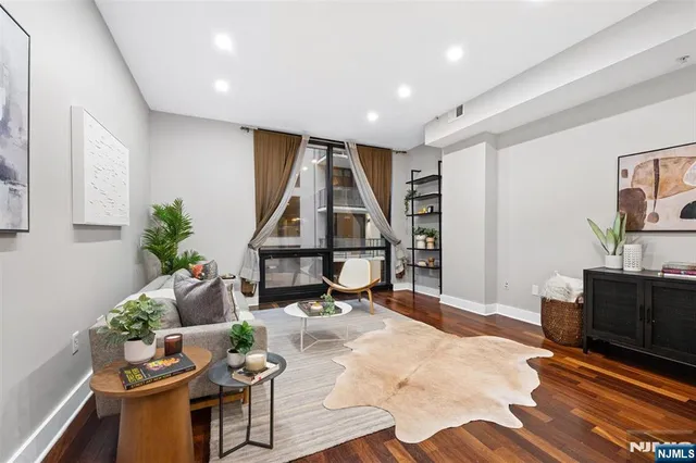 a living room with furniture a piano and a potted plant
