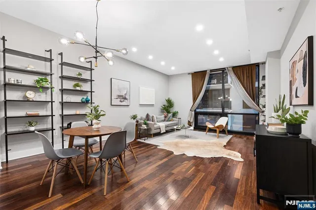 a view of a dining room with furniture a rug and wooden floor