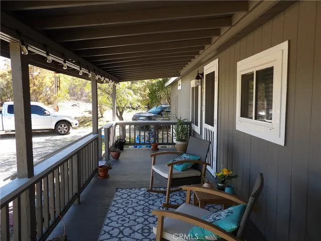 a balcony with wooden floor and outdoor seating