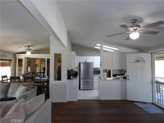 a view of a kitchen with refrigerator and wooden floor