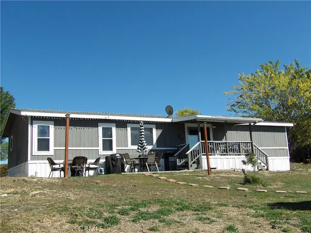 a backyard of a house with fire pit and outdoor seating