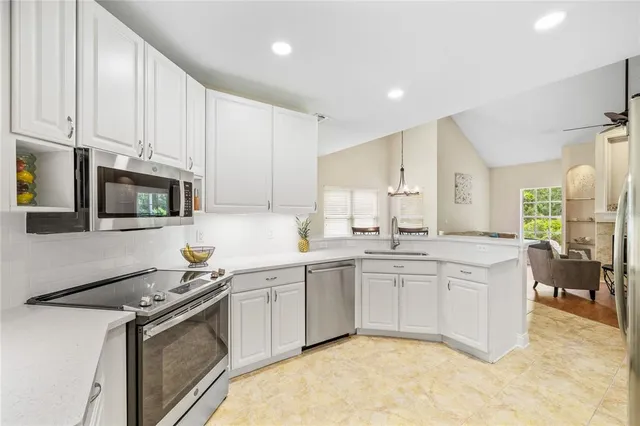 a bedroom with a large bed chandelier and a window