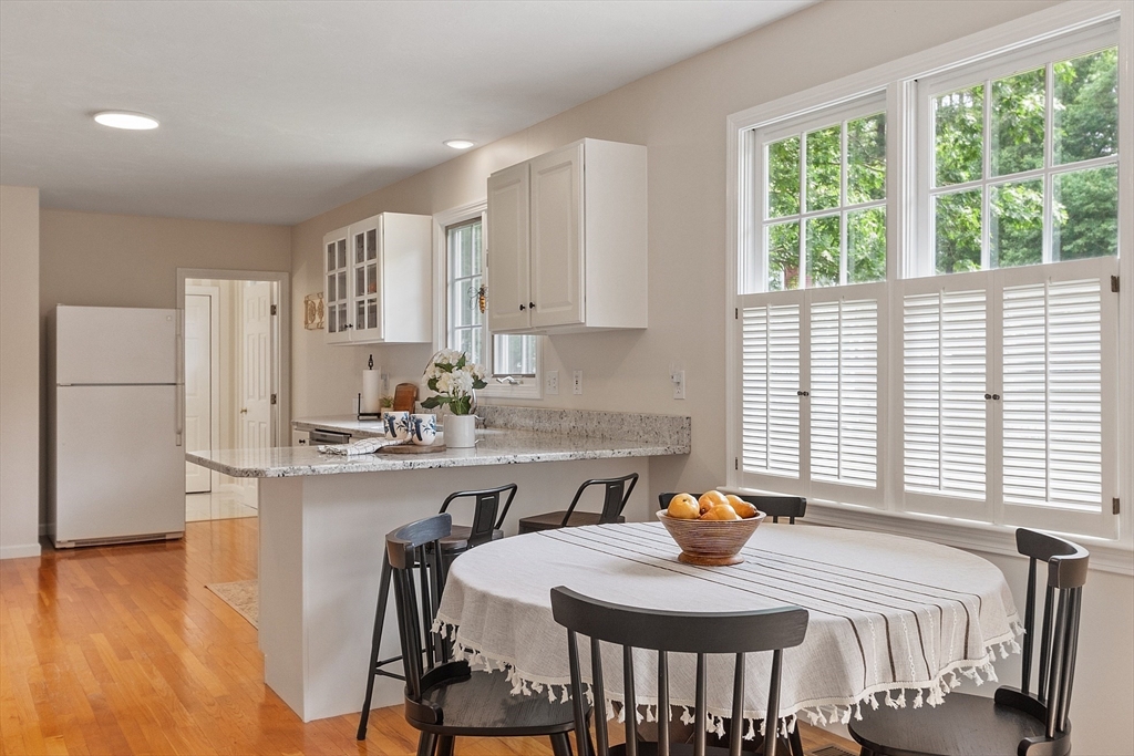 28 Old Harvard Road Boxborough, MA 01719 - Photo 11 of 40 a kitchen with stainless steel appliances granite countertop a stove a refrigerator and a dining table with wooden cabinet