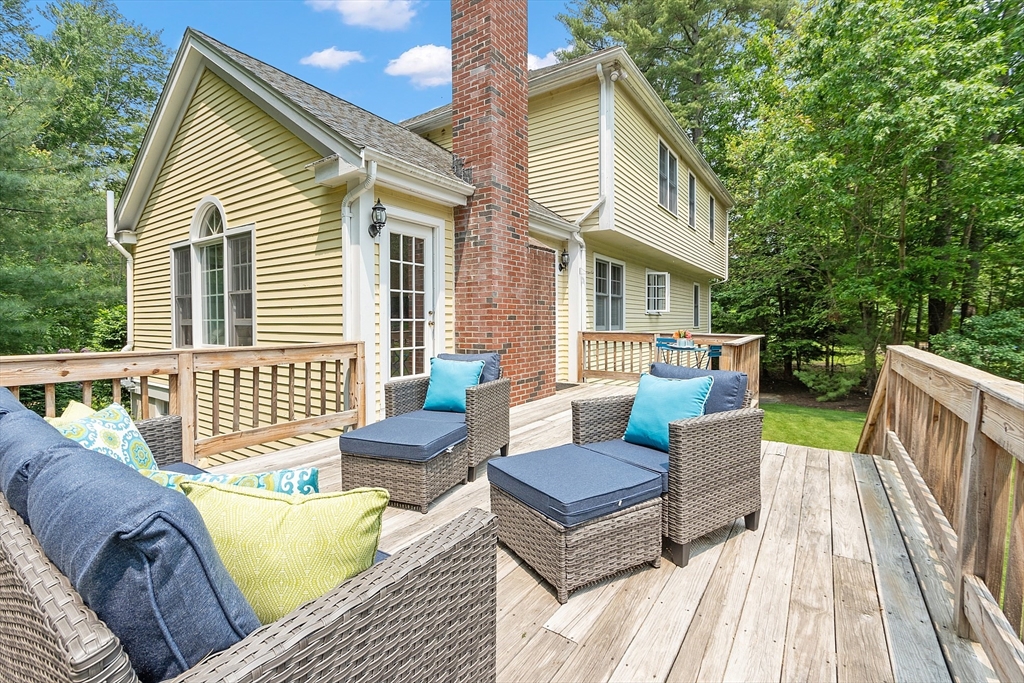 28 Old Harvard Road Boxborough, MA 01719 - Photo 36 of 40 a view of a deck with couches table and chairs with wooden floor and fence