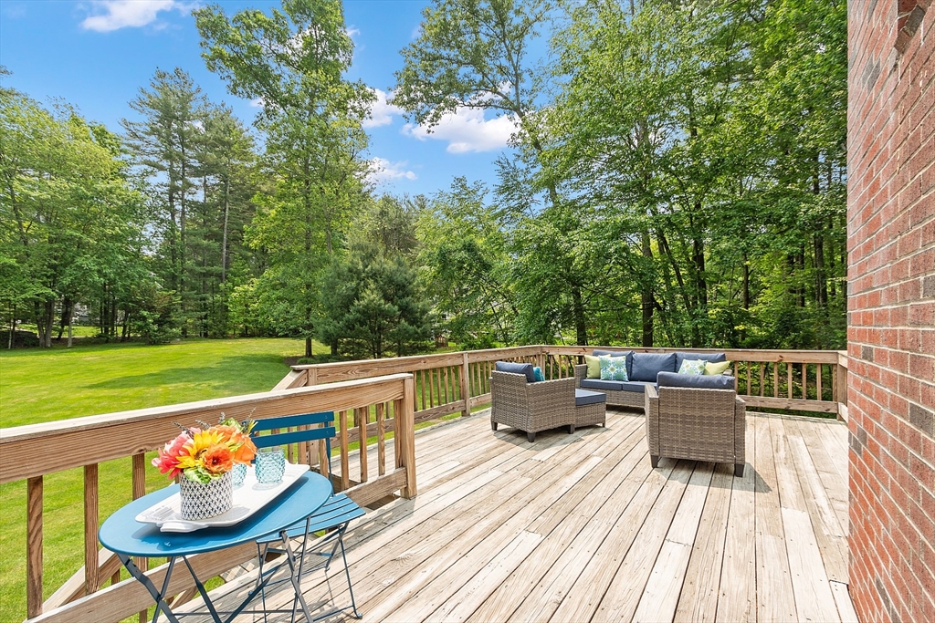 28 Old Harvard Road Boxborough, MA 01719 - Photo 37 of 40 a view of a roof deck with table and chairs couches with wooden floor and fence