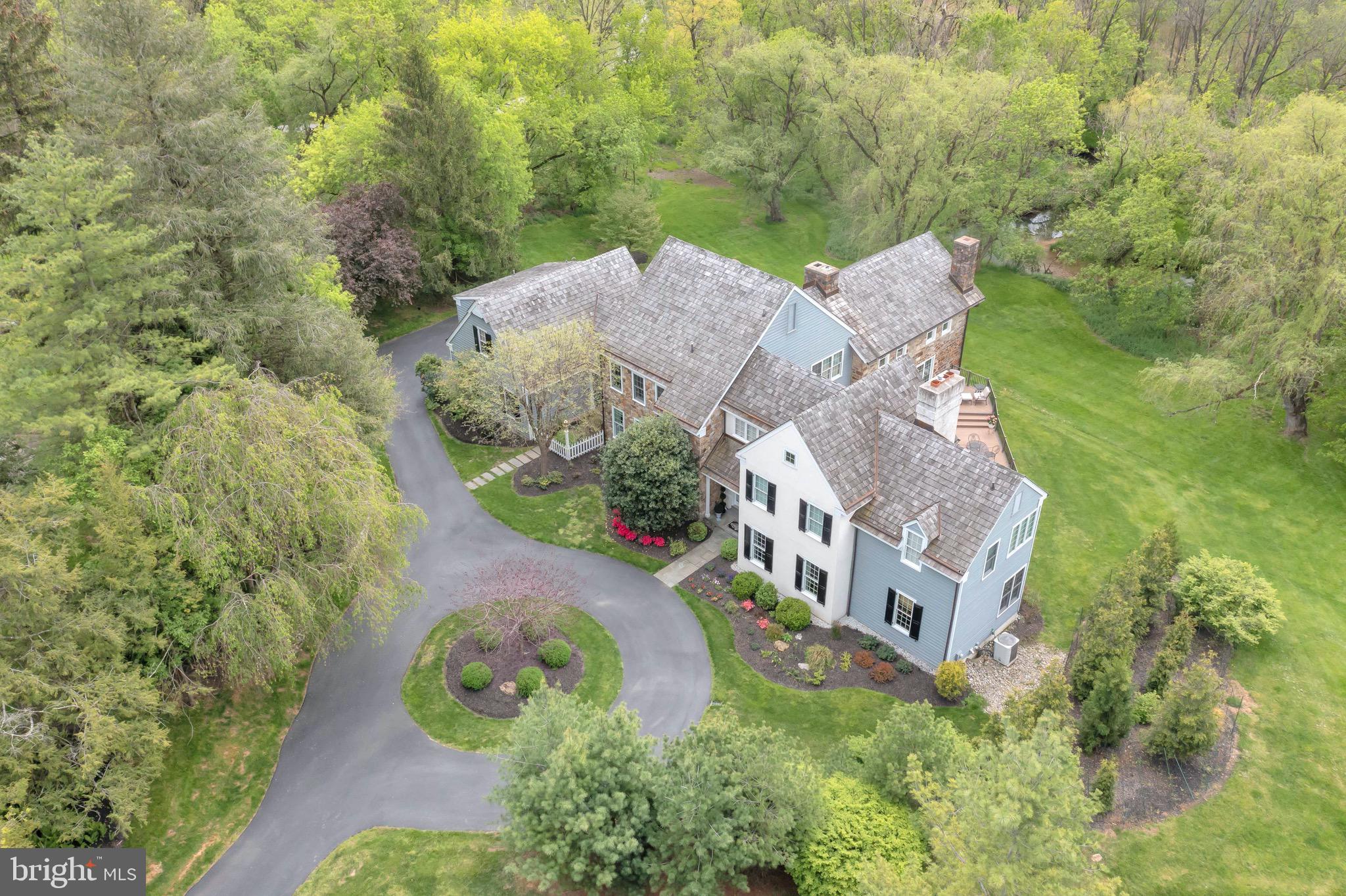 an aerial view of a house with a garden and trees