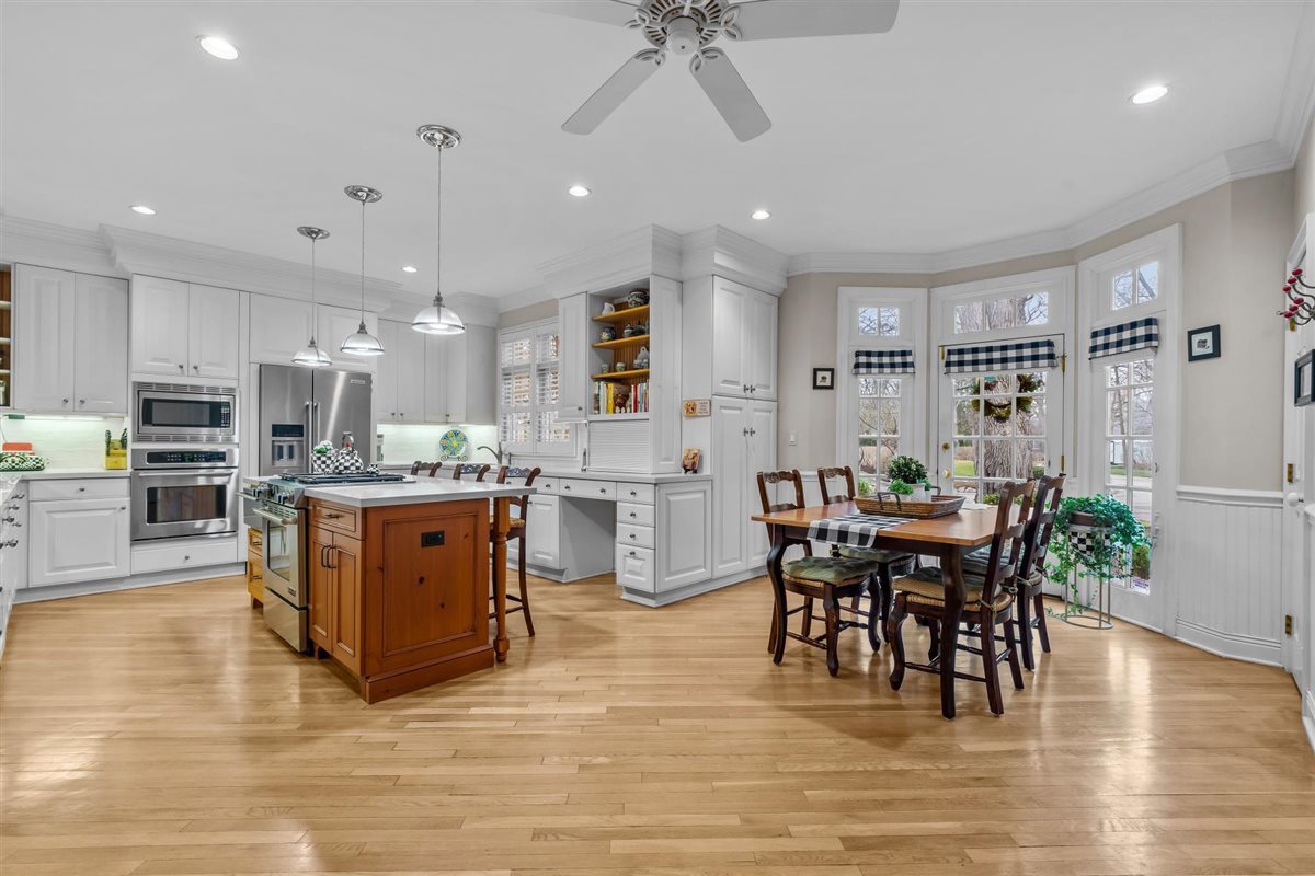 852 Gloucester Crossing Lake Forest, IL 60045 - Photo 8 of 29 a kitchen with stainless steel appliances granite countertop a stove top oven a sink dishwasher a dining table and chairs with wooden floor