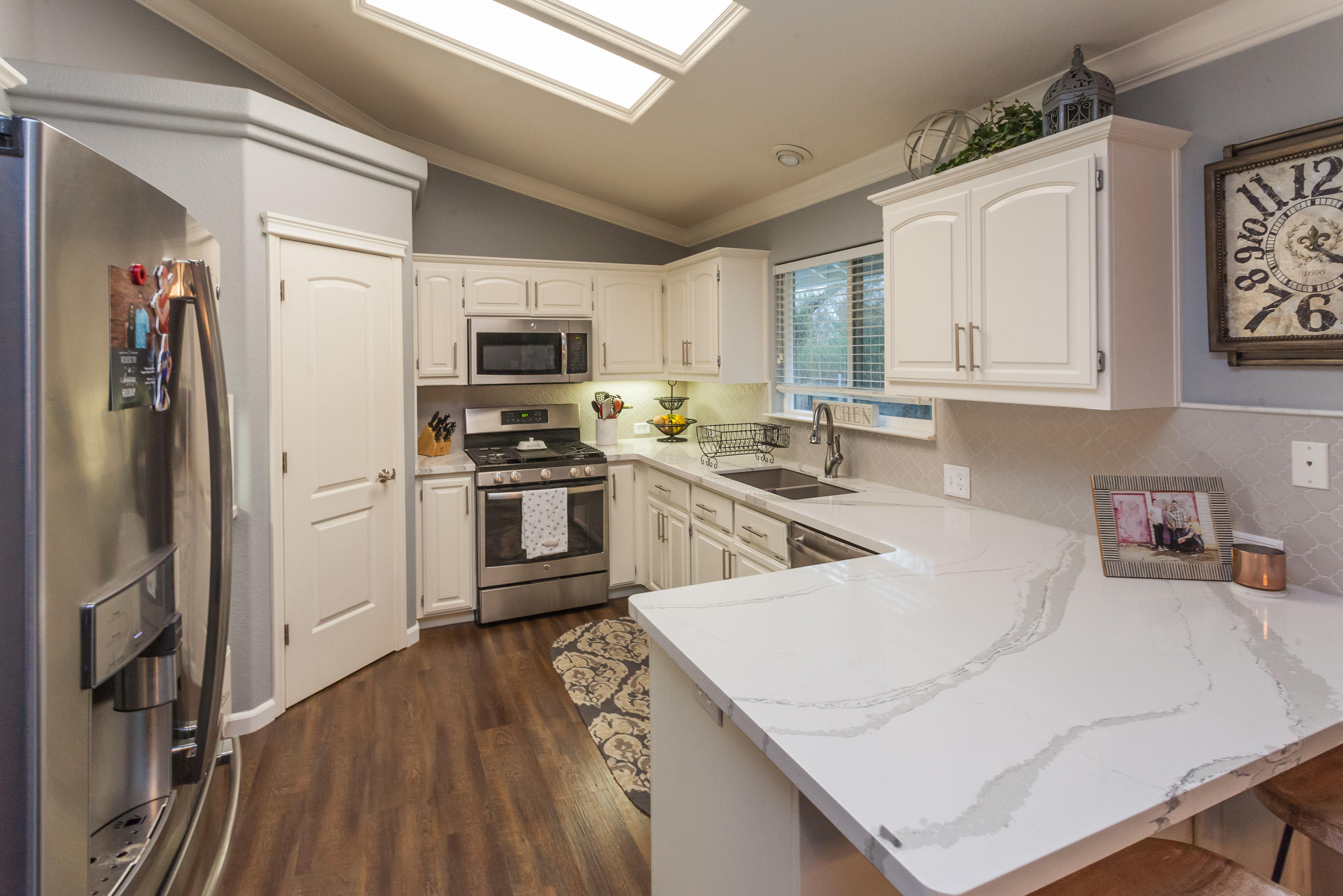 7740 Pit Road Redding, CA 96001 - Photo 6 of 23 a kitchen with a refrigerator a stove top oven a sink and dishwasher with wooden floor