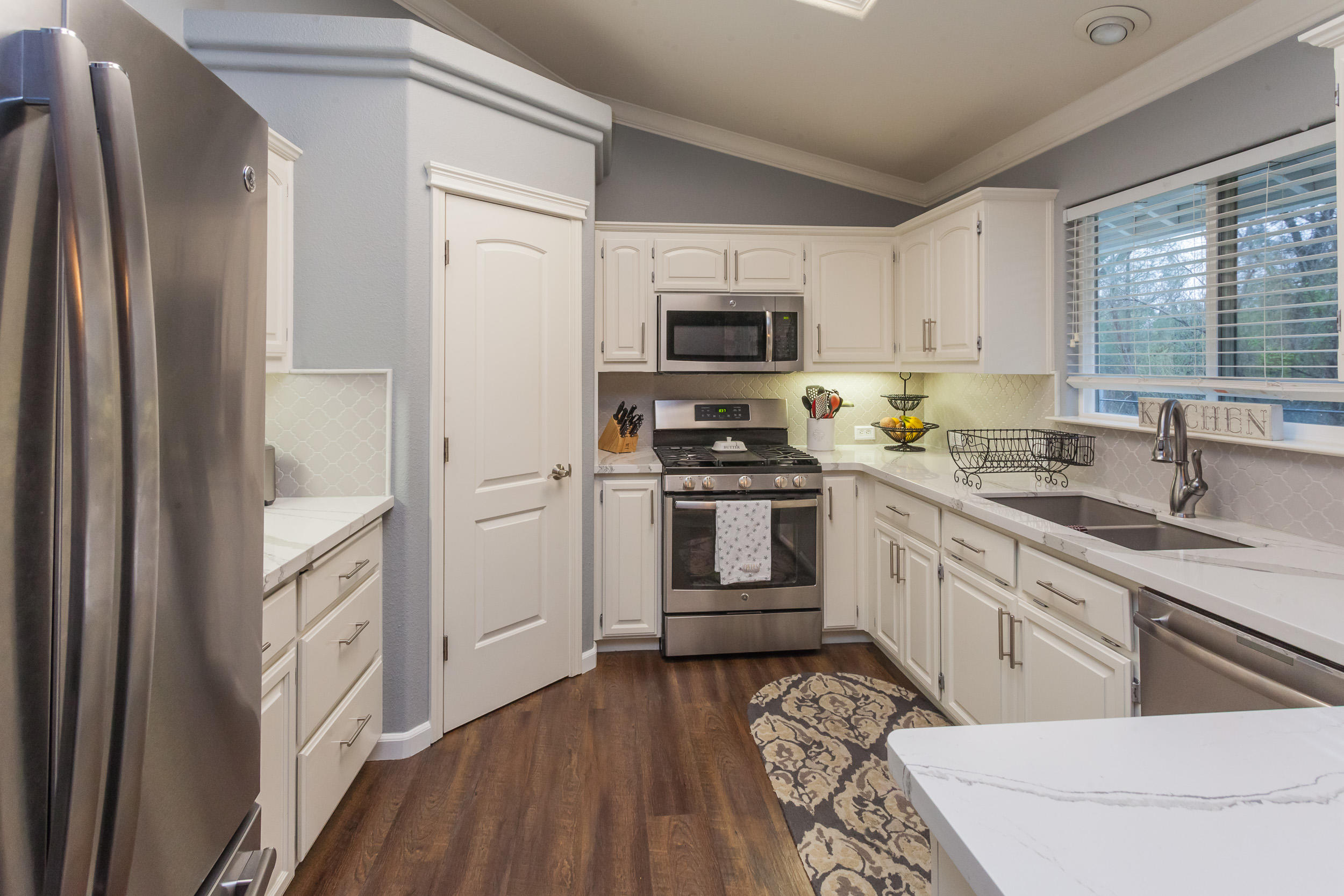 7740 Pit Road Redding, CA 96001 - Photo 7 of 23 a kitchen with white cabinets and white appliances