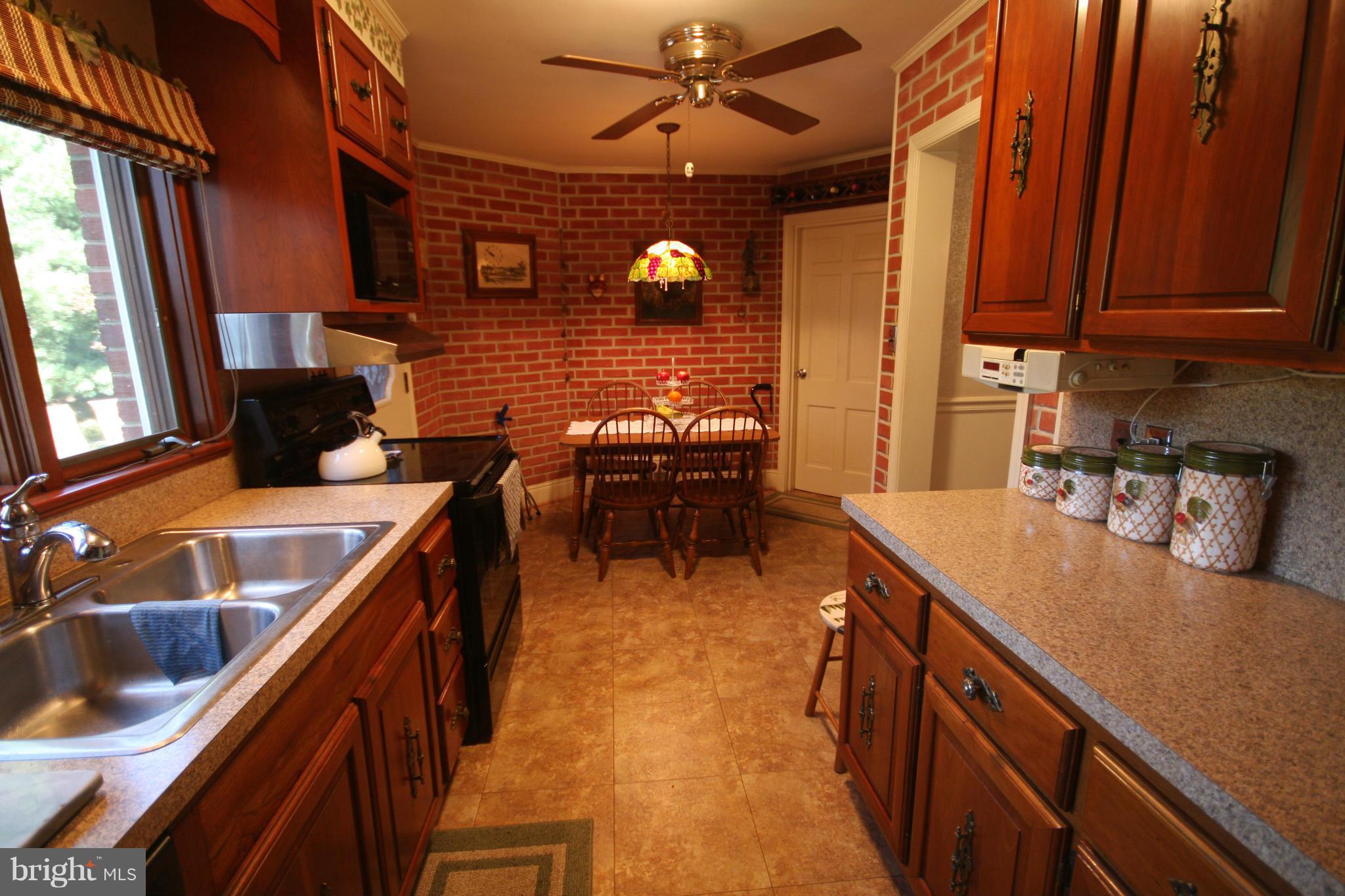 14014 Notley Road Silver Spring, MD 20904 - Photo 18 of 30 a kitchen with a sink and wooden cabinets