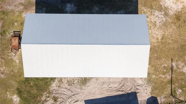 an aerial view of ocean and residential houses with outdoor space