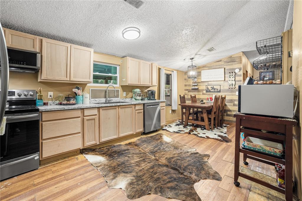 1075 Southwest Rucks Dairy Road Okeechobee, FL 34974 - Photo 44 of 65 a kitchen with stainless steel appliances a stove sink and cabinets