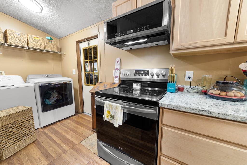 1075 Southwest Rucks Dairy Road Okeechobee, FL 34974 - Photo 48 of 65 a kitchen with stainless steel appliances granite countertop a stove and a microwave