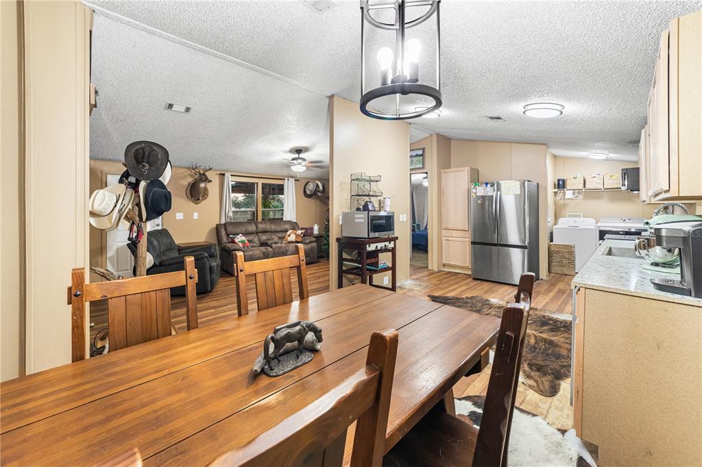 1075 Southwest Rucks Dairy Road Okeechobee, FL 34974 - Photo 52 of 65 a dining room filled chandelier and wooden floor