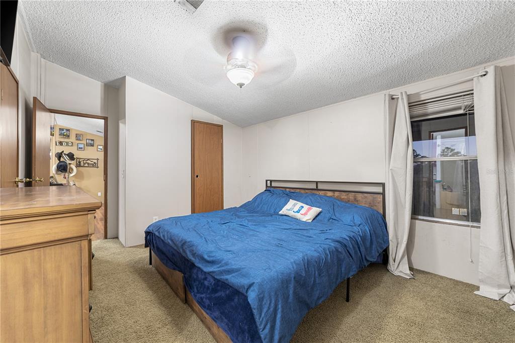 1075 Southwest Rucks Dairy Road Okeechobee, FL 34974 - Photo 65 of 65 a bedroom with a large bed and a chandelier