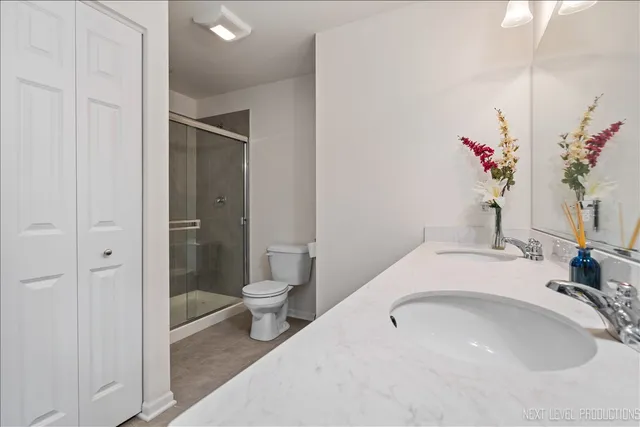 a bathroom with a double vanity sink mirror and toilet