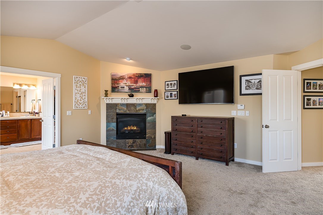3909 219th Street Southeast Bothell, WA 98021 - Photo 18 of 34 a bed room with a flat screen tv and a fireplace