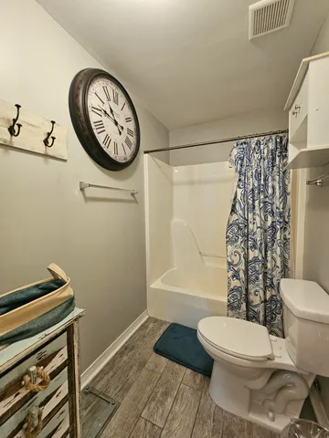 a bathroom with a toilet and a shower curtain
