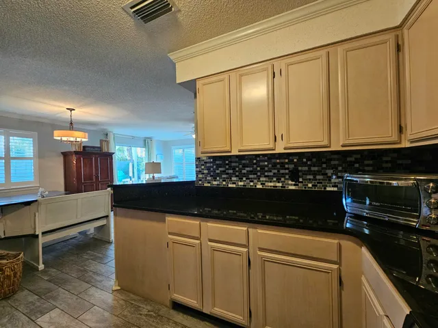 a kitchen with granite countertop a cabinets and a stove top oven