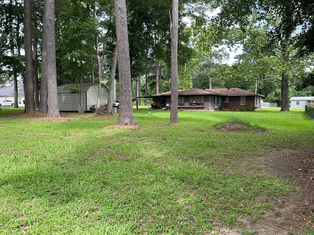 a view of a house with backyard and a tree