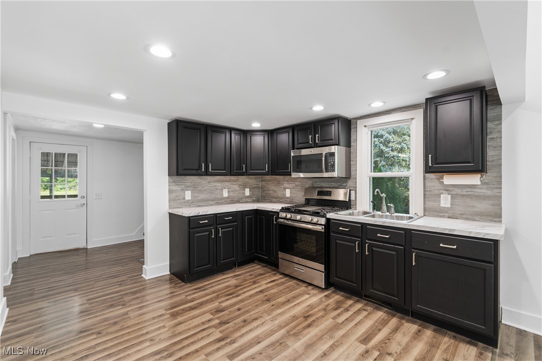 8177 South Cleveland Massillon Road, Unit 55 Clinton, OH 44216 - Photo 8 of 32 Kitchen featuring stainless steel appliances, light hardwood / wood-style floors, a wealth of natural light, and sink