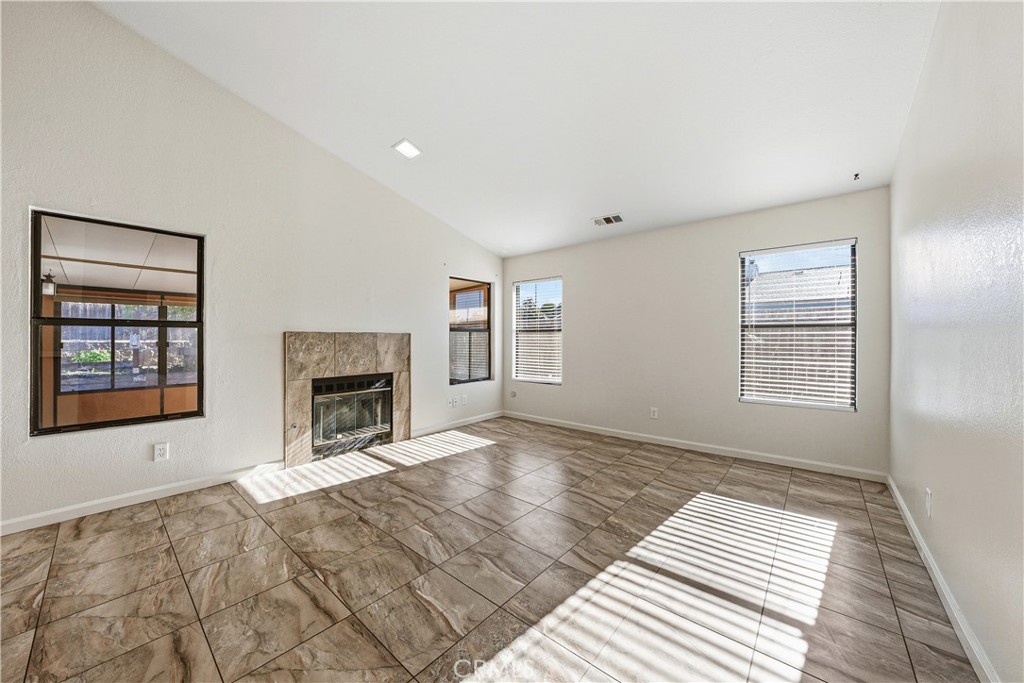 483 Violet Avenue Nipomo, CA 93444 - Photo 16 of 47 a view of an empty room with a fireplace and a window