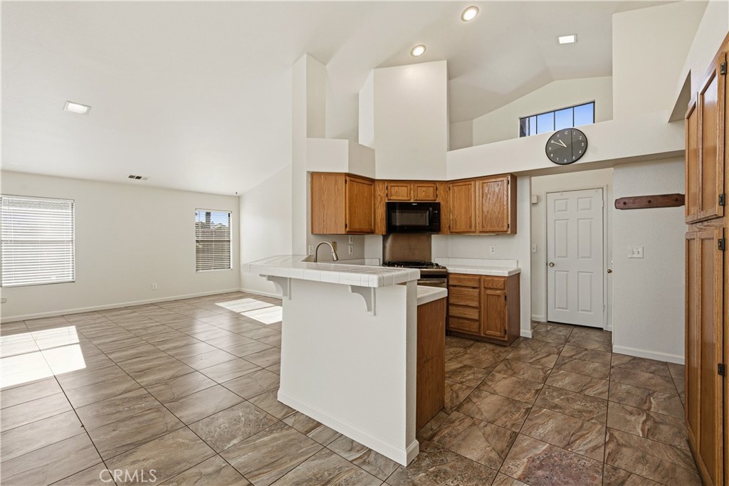 483 Violet Avenue Nipomo, CA 93444 - Photo 8 of 47 a kitchen with stainless steel appliances kitchen island granite countertop a sink and cabinets