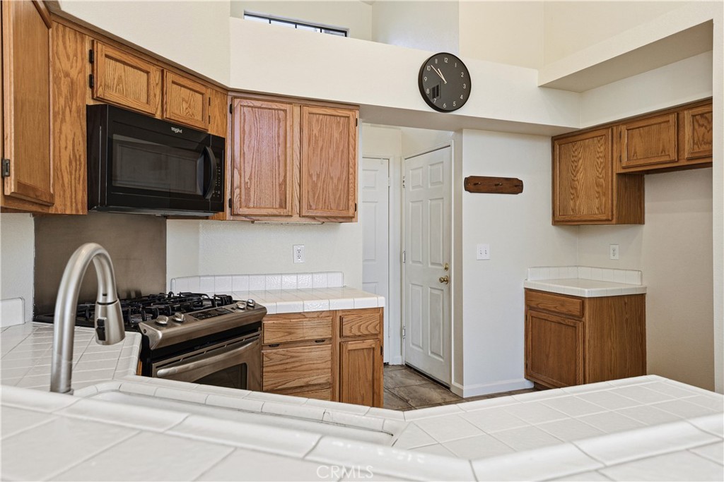 483 Violet Avenue Nipomo, CA 93444 - Photo 9 of 47 a kitchen with stainless steel appliances granite countertop a stove and a microwave