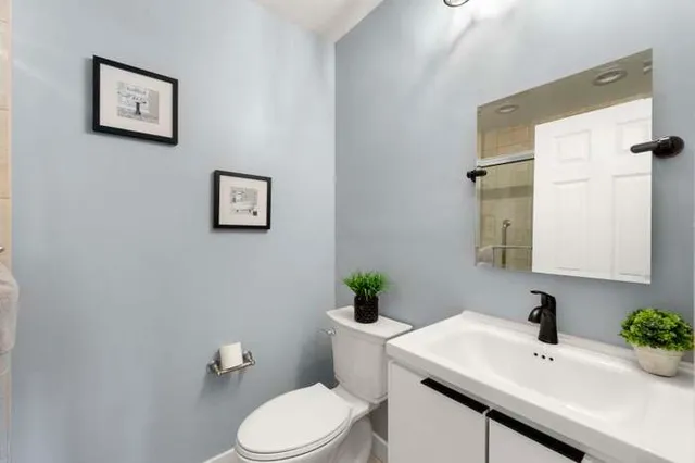 a bathroom with a sink mirror and toilet