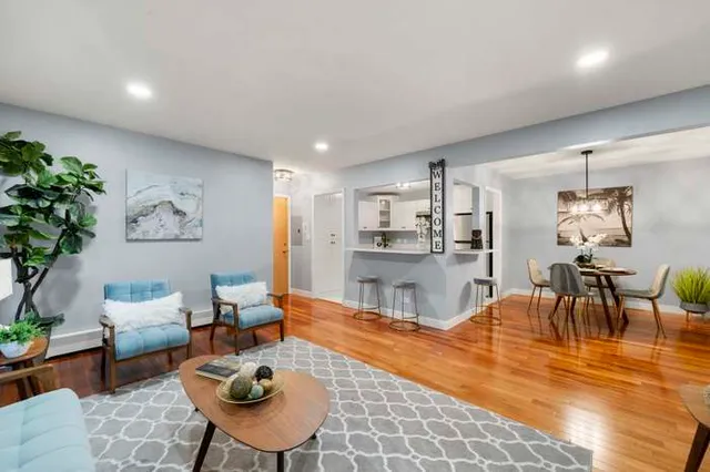 a living room with furniture and a dining table with kitchen view