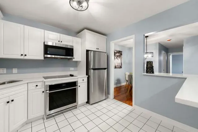 a kitchen with stainless steel appliances kitchen island granite countertop a refrigerator and a stove top oven