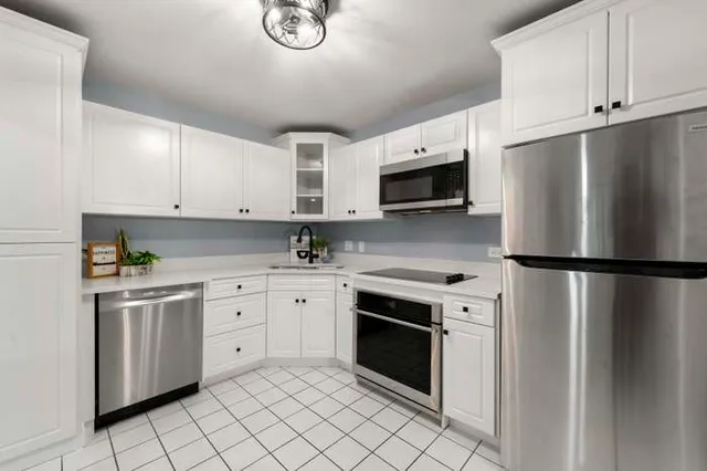 a kitchen with cabinets stainless steel appliances and a counter space