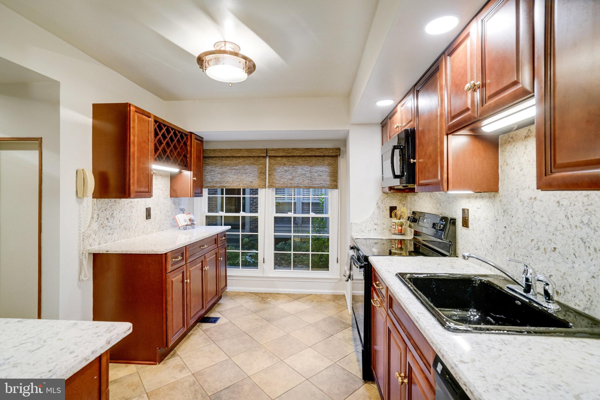2540 South Walter Reed Drive, Unit 4 Arlington, VA 22206 - Photo 16 of 40 a kitchen with stainless steel appliances granite countertop a stove a sink and a refrigerator