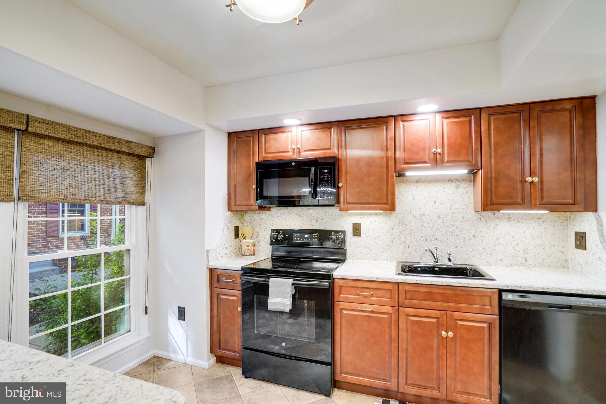 2540 South Walter Reed Drive, Unit 4 Arlington, VA 22206 - Photo 17 of 40 a kitchen with stainless steel appliances granite countertop a stove a sink and a microwave
