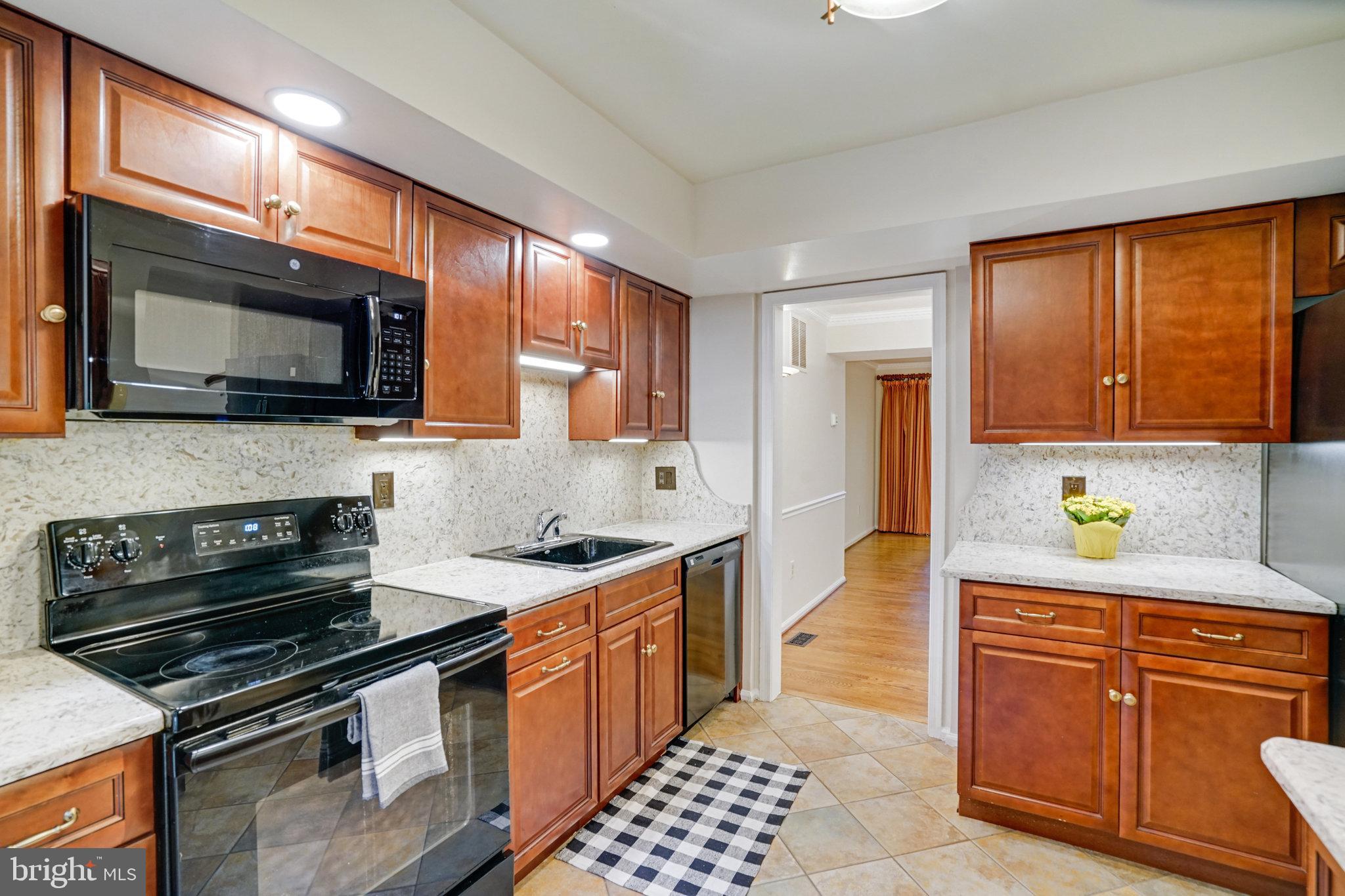2540 South Walter Reed Drive, Unit 4 Arlington, VA 22206 - Photo 20 of 40 a kitchen with stainless steel appliances a stove sink microwave and cabinets