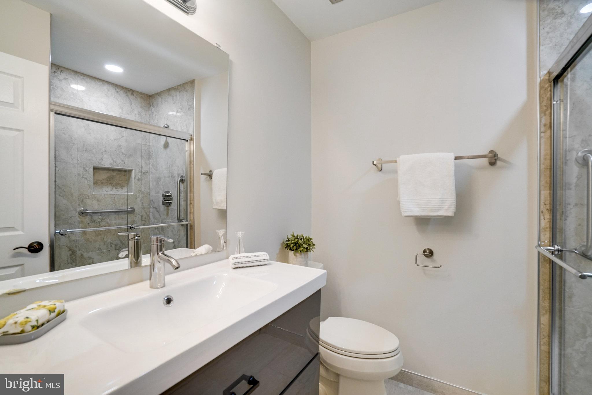 2540 South Walter Reed Drive, Unit 4 Arlington, VA 22206 - Photo 33 of 40 a bathroom with a sink toilet and a mirror
