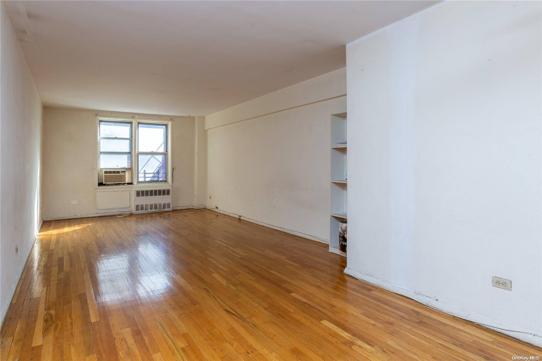 41-07 Bowne Street, Unit 3K Queens, NY 11355 - Photo 7 of 17 an empty room with wooden floor and windows