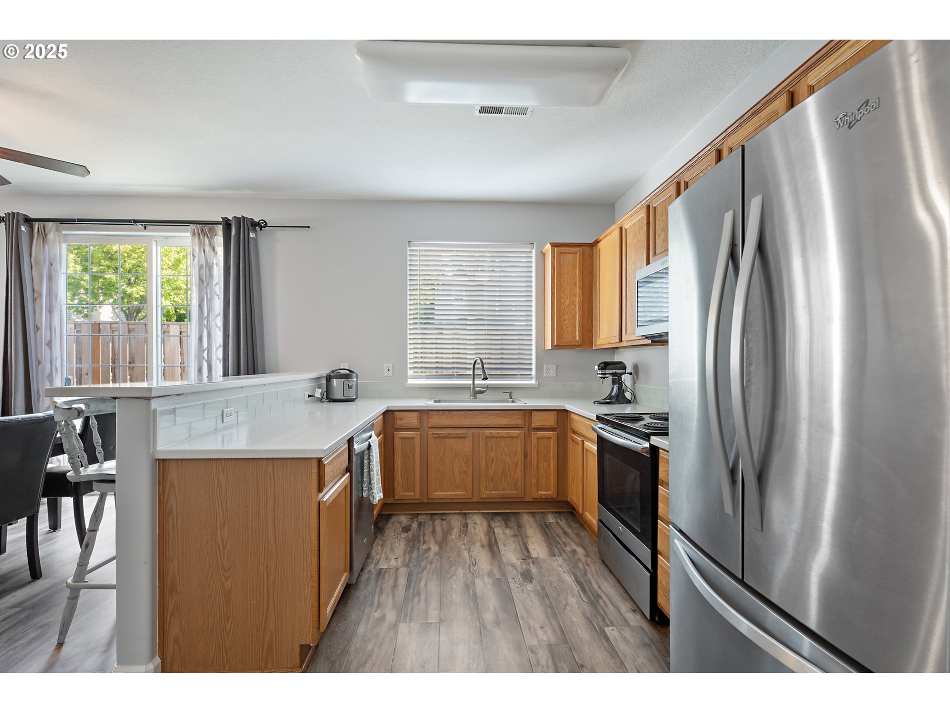 6255 Southwest 182nd Terrace Beaverton, OR 97007 - Photo 17 of 42 a kitchen with stainless steel appliances granite countertop a refrigerator a sink dishwasher a stove and white countertops with wooden floor