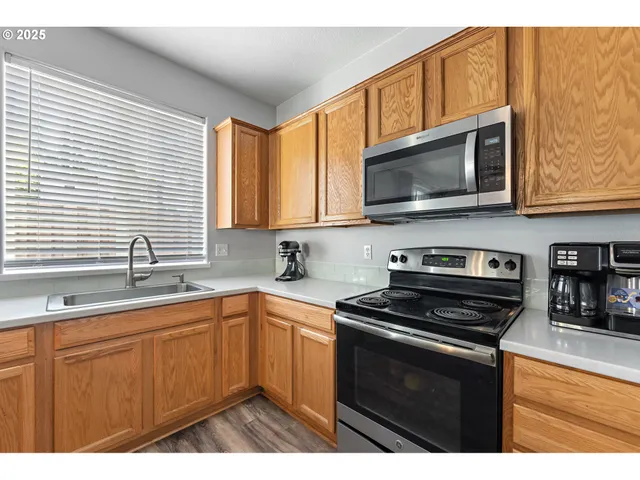 a kitchen with stainless steel appliances a stove sink microwave and cabinets