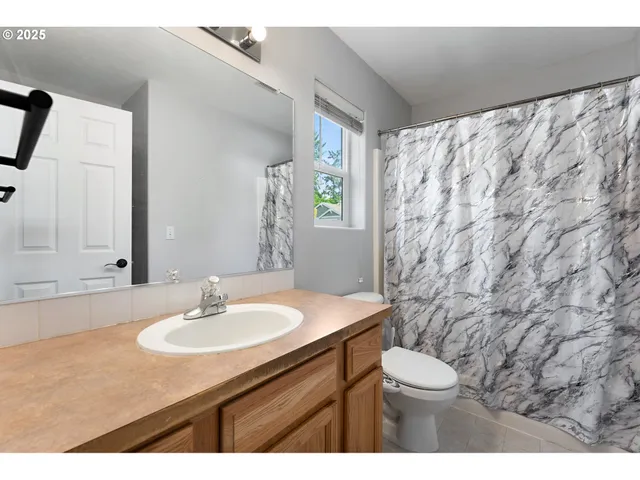 a balcony with table and chairs and potted plants