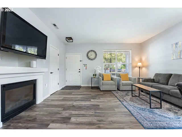 a living room with furniture a fireplace and a flat screen tv