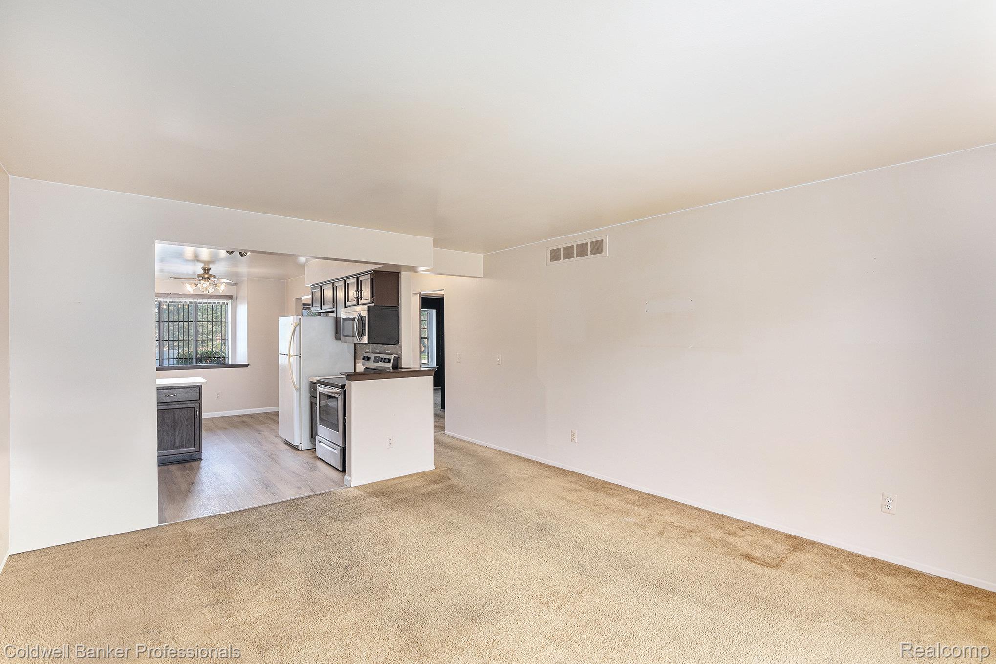 57295 Beaconsfield Road Washington, MI 48094 - Photo 5 of 20 Unfurnished living room with light colored carpet and baseboards