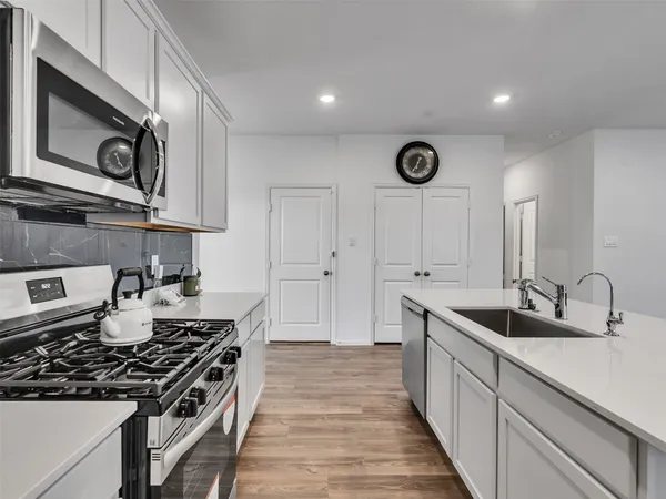 a kitchen with stainless steel appliances granite countertop a sink and a stove