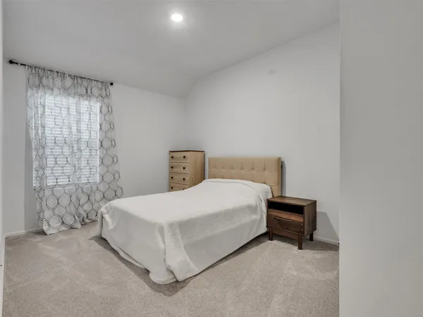 a spacious bedroom with a bed and a window