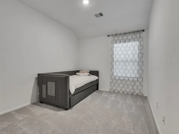 a spacious bedroom with a bed and a window