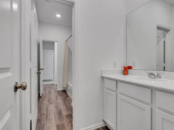 a bathroom with a sink vanity granite tub shower and a mirror
