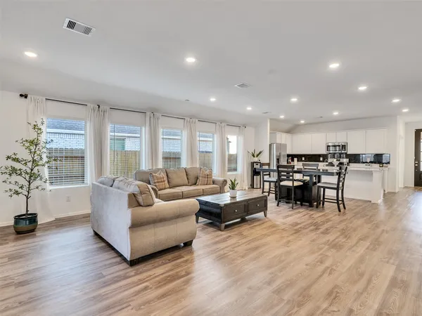 a living room with furniture and a wooden floor