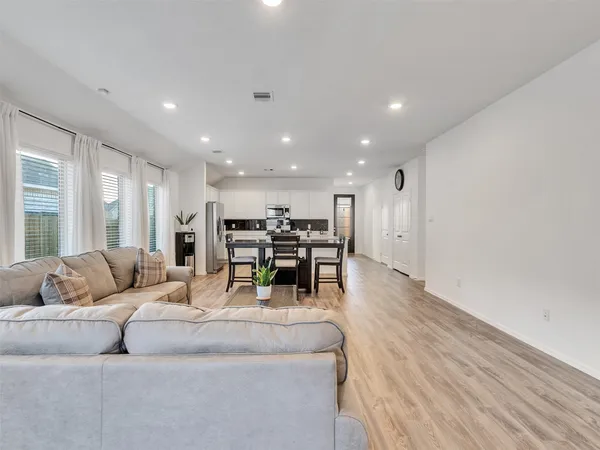 a living room with furniture and kitchen view with a couch